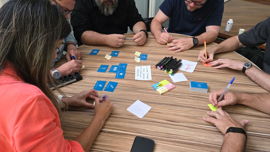 Diverse team engaged in a brainstorming session with cards and sticky notes on a round table.